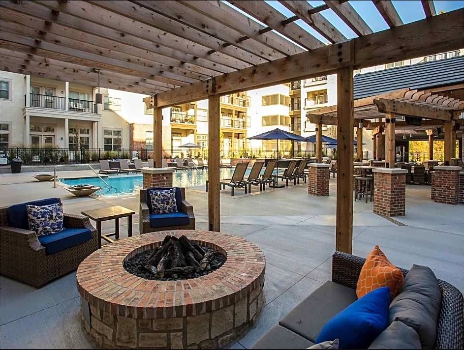 Mission 106 Luxury Apartments building exterior and courtyard with pool, lounge seating, and a fire pit