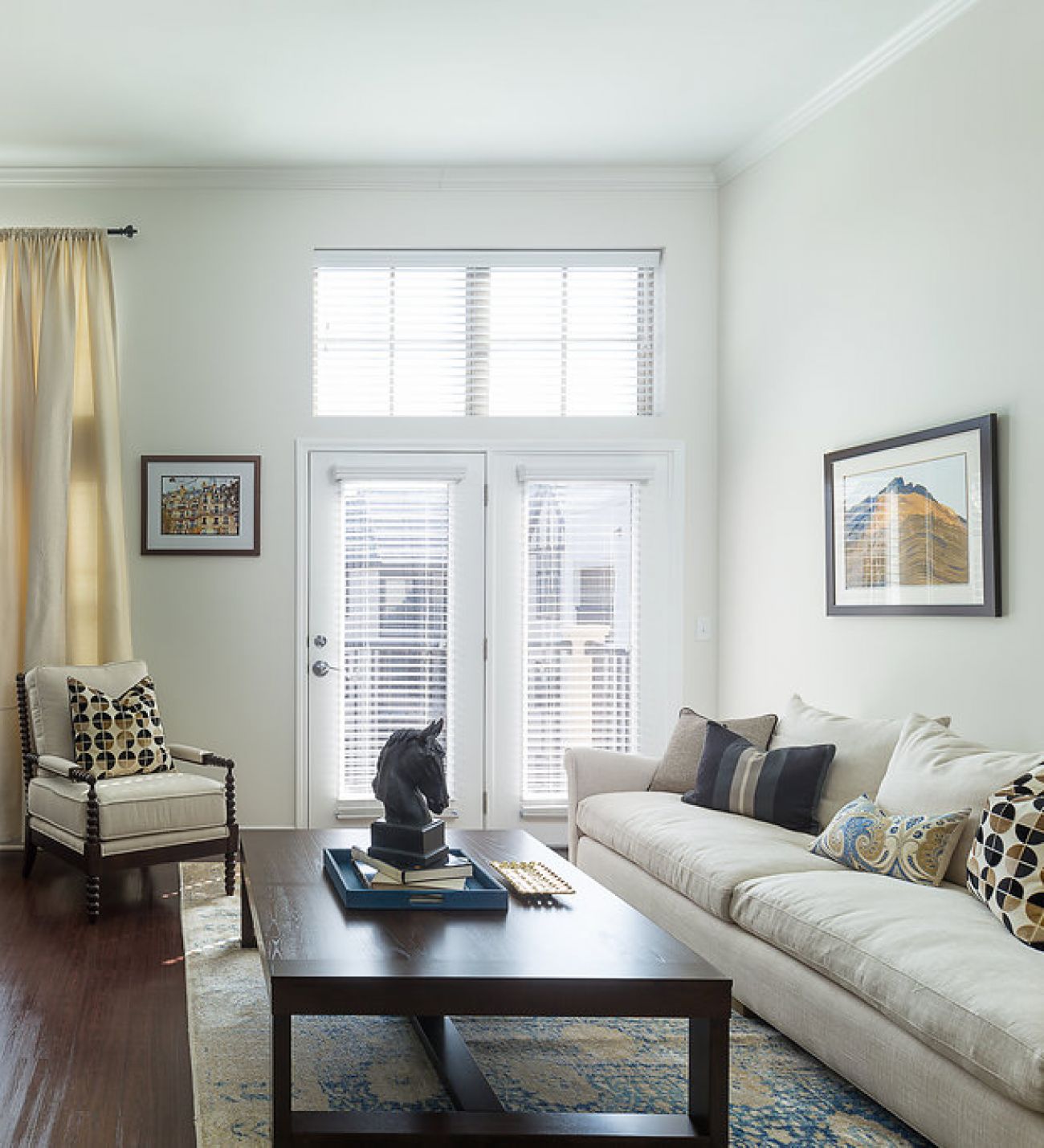 Mission 106 Luxury Apartments living room with a couch, coffee table, chair, rug, and floor-to-ceiling windows