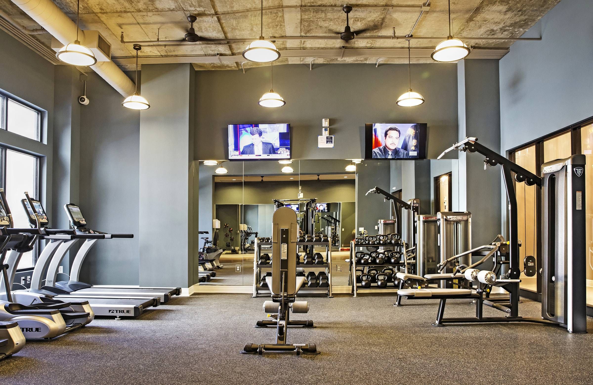 Mission 106 Luxury Apartments fitness center with exercise machines, a wall-mounted TV, and fitness equipment