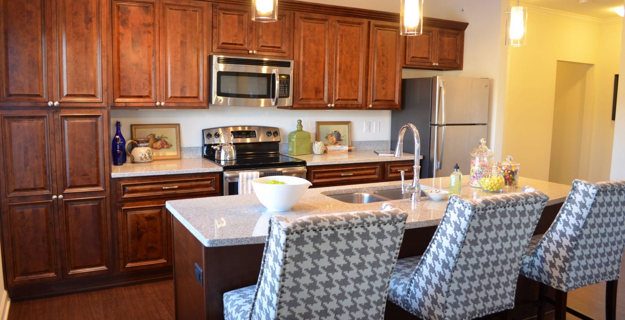 Mission 106 Apartments kitchen with kitchen island, bar chairs, beautiful finishes, and floor-to-ceiling cabinets